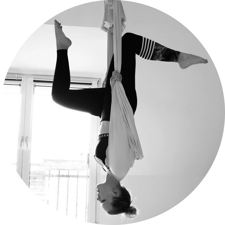 Martha, certified yoga instructor, demonstrating a Aerial pose in a bright studio
