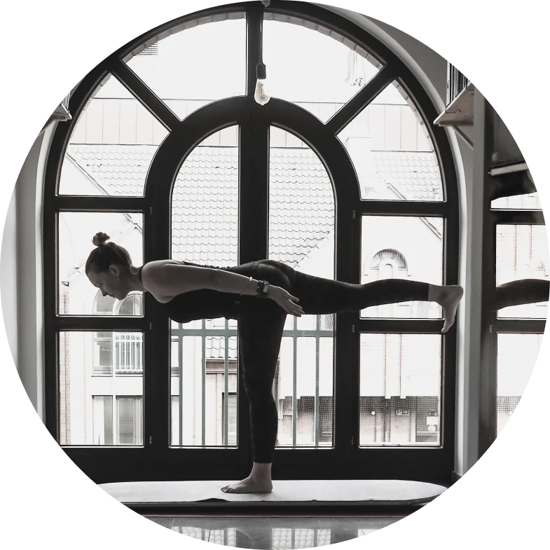 Martha, certified yoga instructor, demonstrating a yoga board pose in a bright studio